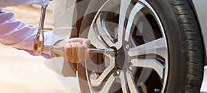 Close up hand of mechanic hands using wrench to changing a car tire.