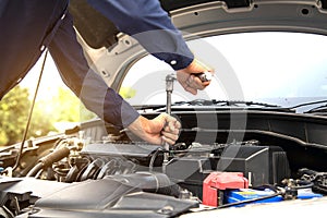 Close up hand of mechanic hands using wrench to repair a car engine.