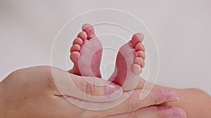 Close up Hand of Mother holding baby newborn foot with love.Small and tiny baby feet on parent hand at cozy home.Comfortable Mood