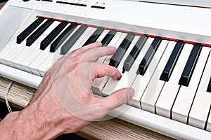 Close-up of the hand of a musical artist playing the piano, a man`s hand, classical music, keyboard, synthesizer, pianist