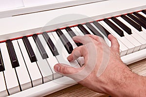 Close-up of the hand of a musical artist playing the piano, a man`s hand, classical music, keyboard, synthesizer, pianist