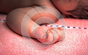 A little hand of newborn baby with light at postpartum care unit in hospital when she sleeping with her mother, so cute.