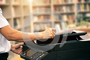 Close up hand office man insert paper on panel to using the copier or photocopier machine for scanning document