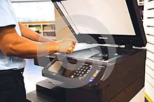 Close up hand office man put and scanning paper on panel to using the copier or photocopier machine for scanner