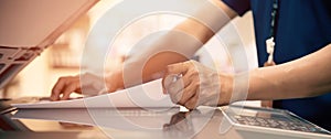 Close up hand office man scanning papers on panel to using the copier or photocopier machine for document