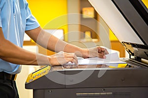 Close up hand office man using the copier or photocopier machine for scanning document printing a sheet paper and