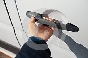 Close-up of hand opens handle of car door