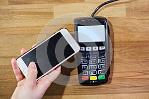 Close up hand paying order by credit card on payment terminal in the coffee shop