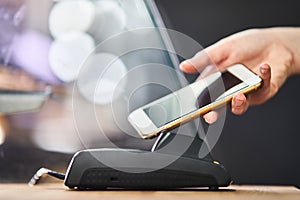 Close up hand paying order by credit card on payment terminal in the coffee shop