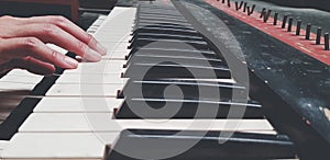 Close up hand of people playing piano or press elect tone keyboard in vintage color style photo