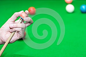 Close up hand player snooker using chalk rubbing a cue photo