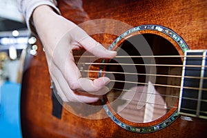 Close up of hand playing acoustic guitar, musical performance, selective focus