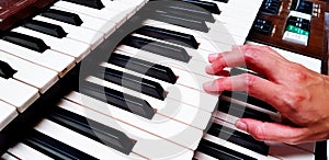 Close up hand playing piano or press elect tone keyboard. photo