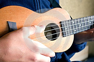 Close-up of a hand playing a ukulele