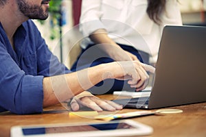 Close up of a hand pointing a laptop screen