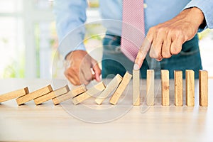 Close-up hand prevent wooden block not falling domino concepts of financial risk management and strategic planning and business