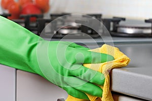 Close-up of a hand in a protective glove holding a rag. Cleaning the kitchen