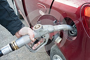 Close-up of a hand pumping gas in the car with a gas pump