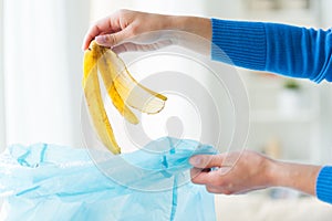 Close up of hand putting food waste to rubbish bag