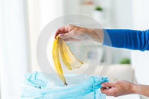 Close up of hand putting food waste to rubbish bag