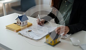 Close up hand of real estate investment and home insurance signing contracts in accordance with the home buying