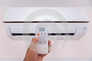 Close up hand and remote control air condition