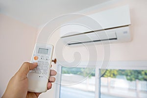 Close up hand and remote control air condition