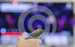 Close-up of hand with the remote control television and presses the button. Television remote control changes channels thumb on