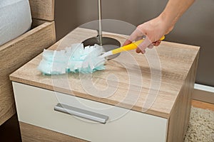 Close-up Of Hand Removing Dust With Duster Feather