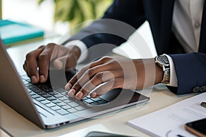 Close up. hand's black business man wearing suit typing and working on laptop computer on wooden table at home office.