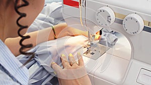 Close-up of hand seamstresses working on a new order using a sewing machine