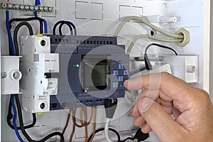Close up of a hand setting up a PLC. Testing and programming of an industrial control system photo