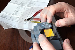 Close-up of a hand setting up a mini PLC. Automatic control system.