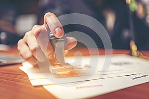 Close-up hand stamping of businessman for signing approval on do photo