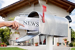 Hand Taking Newspaper From Mailbox photo