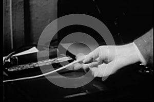 Close-up of hand tearing teletype tape out of machine