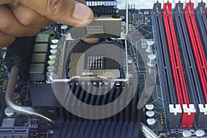 Close up hand of technician putting CPU on the socket of computer motherboard