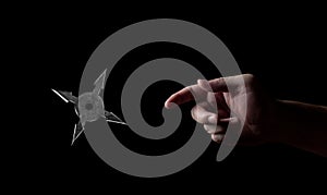 Close up Hand Throwing Ninja Star Shuriken Isolated on Black Background