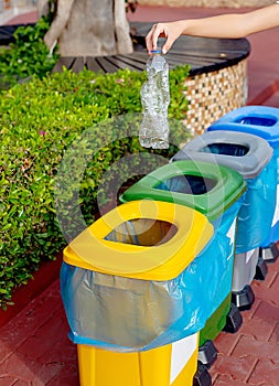 Close up hand throwing plastic bottle recycling container garbage sorting rubbish collection bin.