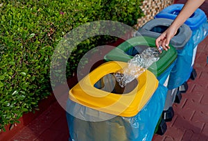 Close up hand throwing plastic bottle recycling container garbage sorting rubbish collection bin.