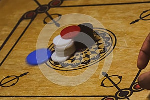 Close-up of a hand throwing a striker into the game board