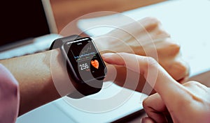 Close up of hand touching smartwatch with health app on the screen.