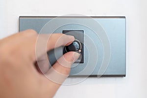 Close up hand turning on grey dimmer switch