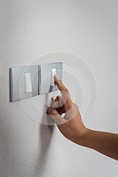Close up hand turning on or off on grey light switches