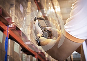 Close up hand of warehouse worker pushing buttons on barcode scanner. Computer equipment for warehouse inventory management