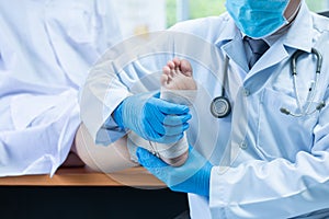Close-up hand wear medical gloves doctor examines the leg of the womanâ€™s heel for heel spurs, pain in the foot, plantar