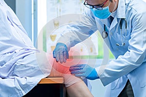 Close-up hand wear medical gloves doctor examining head of patient with knee problems in clinic, Concept of medical orthopedic