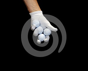 Close-up of a hand wearing a golf glove holding some golf balls between the fingers