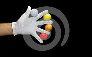 Close-up of a hand wearing a golf glove holding some golf balls between the fingers. Covid-19 concept