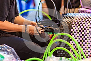 Close up hand of weaver during weaving basket made from plastic